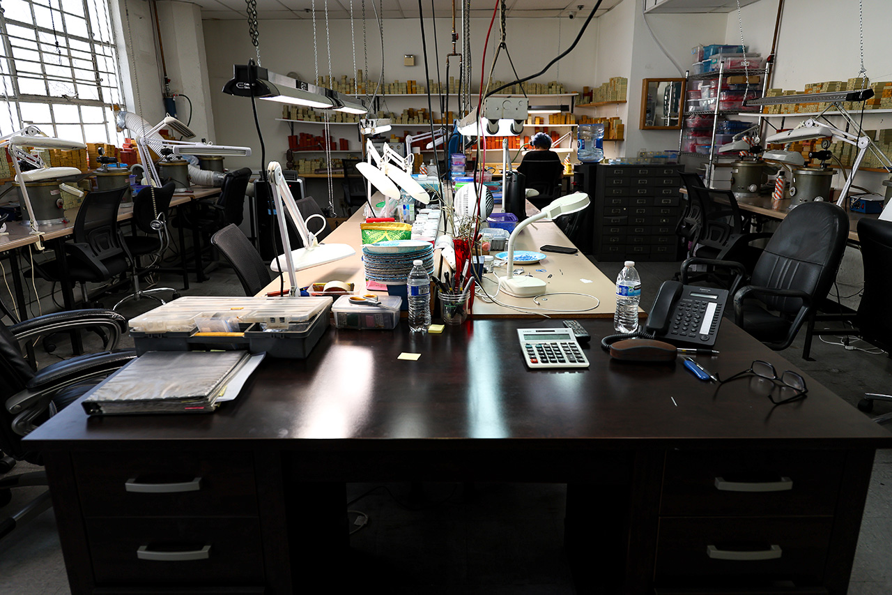 Skilled artisan assembling custom gold jewelry with precision at USA manufacturing facility