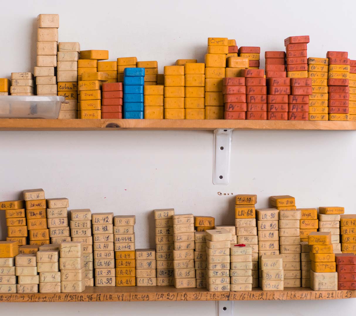 USA jewelry manufacturing workspace compared to overseas factory floor with tools and materials
